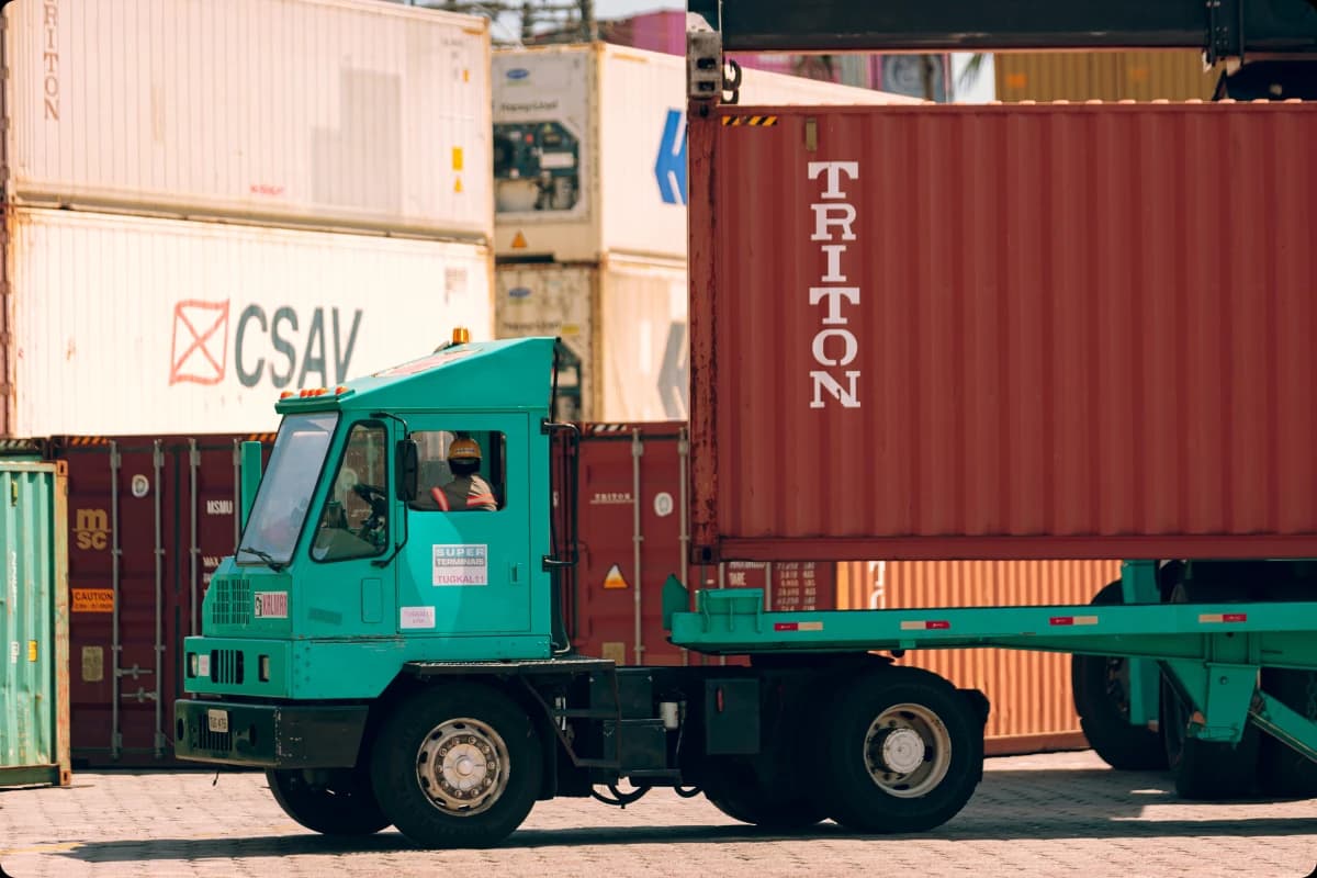 Caminhão transportando cargas no terminal portuário, representando logística sustentável